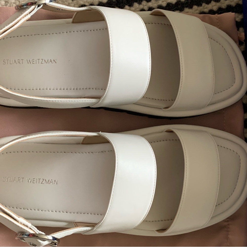 Stuart Weizmann white leather sandals with black bottom sole.